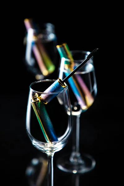 glass of champagne with ice and lemon on black background