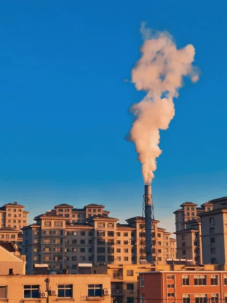 factory chimney and smoke from the chimneys of the building.