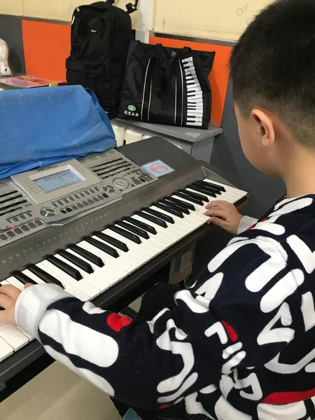 boy playing piano with a toy