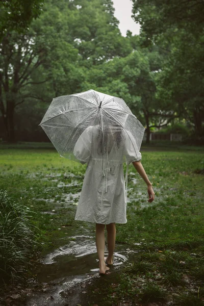 young woman in a raincoat in the rain