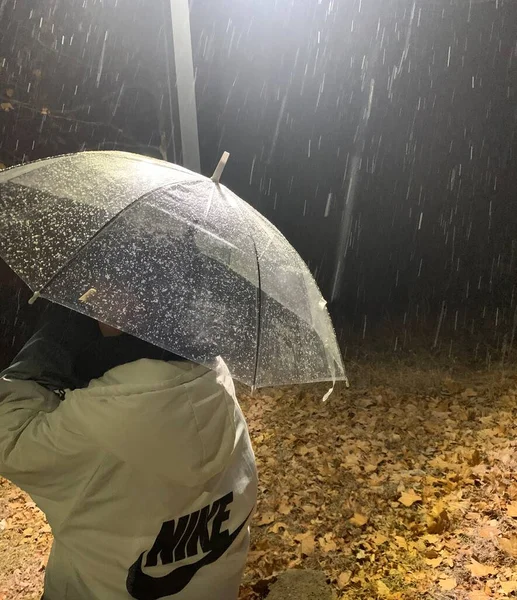 a man in a raincoat with a backpack and a umbrella