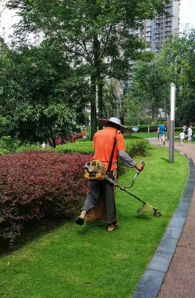 man in a green jacket and a hat with a backpack on the lawn