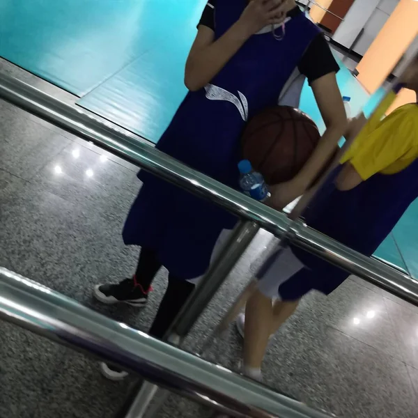 young woman with basketball ball in gym