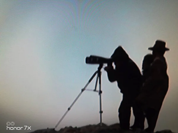 silhouette of a man with a camera on the background of the sea