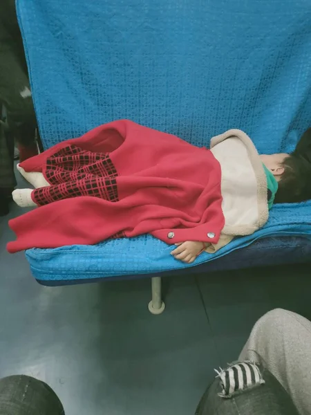 a man in a red shirt and a white sweater is sitting on a chair