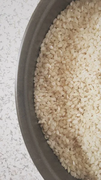 raw rice in a bowl on a white background