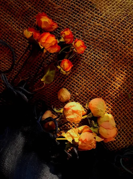 still life with a bouquet of roses and a red rose on a dark background