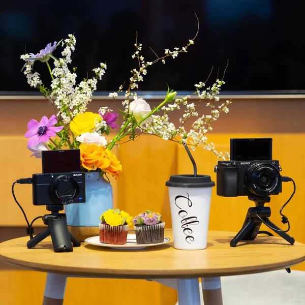 vintage camera with flowers and coffee on a table