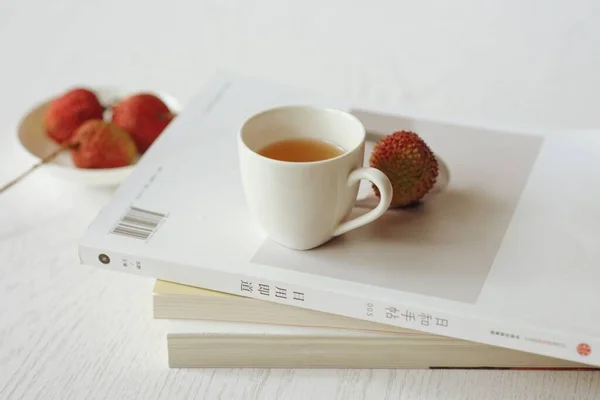 cup of tea with coffee and a book on a white background