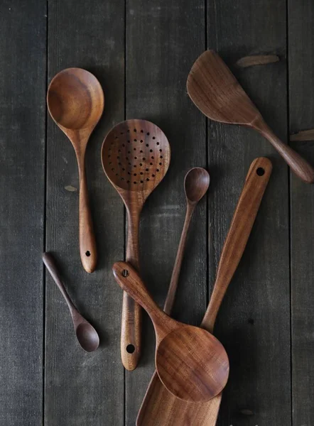 wooden spoons and spoon on a dark background