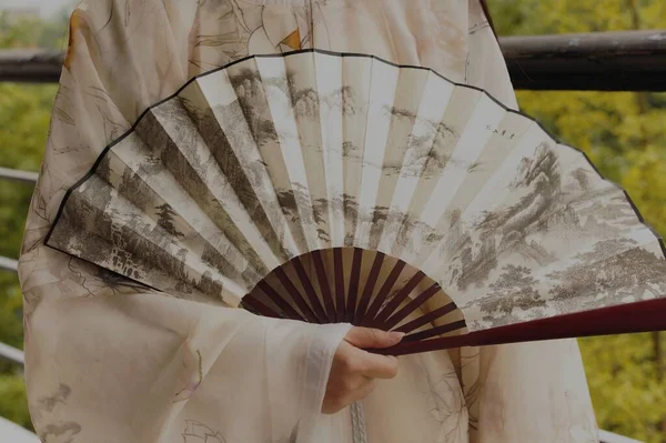 woman holding a fan in the hands of a girl