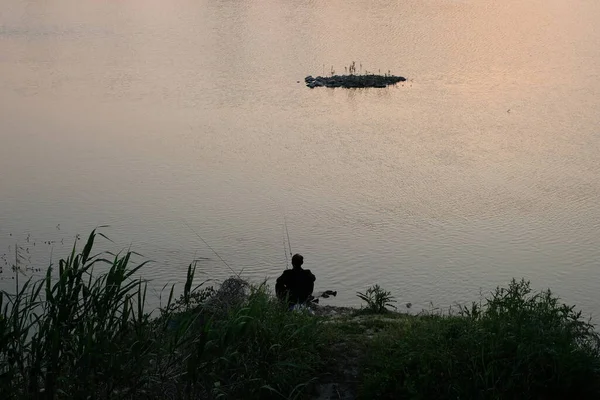 silhouette of a man on the lake