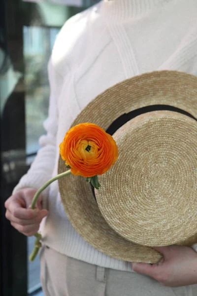 a man in a hat with a flower in her hands