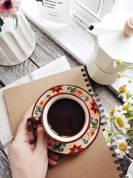 cup of coffee and flowers on white wooden background