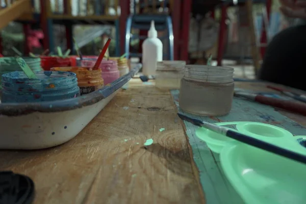 artist paints palette in the workshop