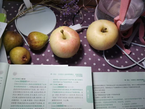 book with apples and books on a background of a wooden table