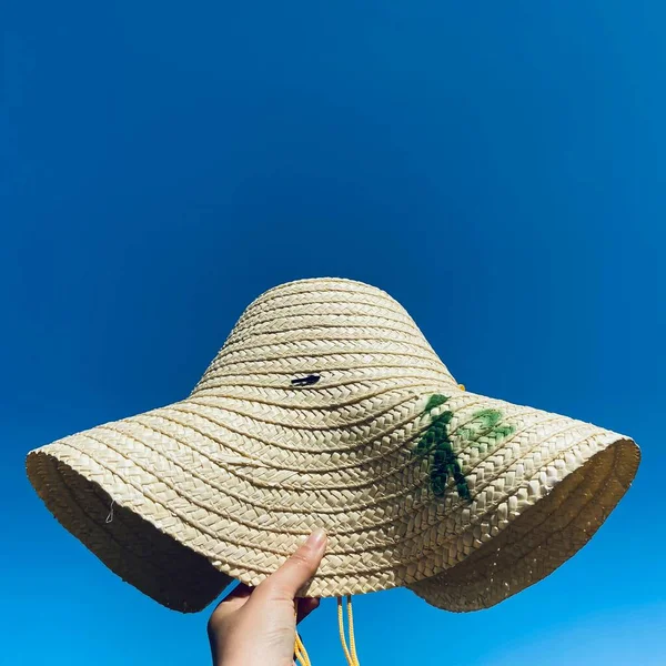 woman in hat and straw hats on blue background