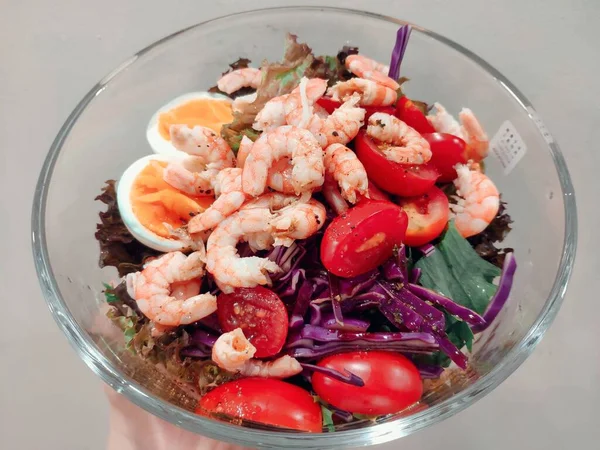 fresh salad with shrimps, shrimp, squid, tomato, onion, lettuce, olives, seafood