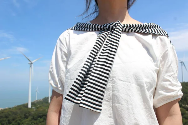 young woman with wind turbine on the beach