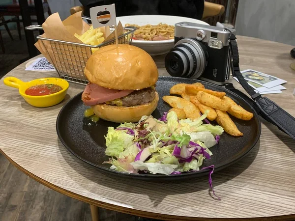 delicious burger with meat and vegetables on wooden table