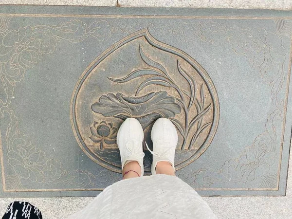 feet of a woman in a white sneakers on the floor