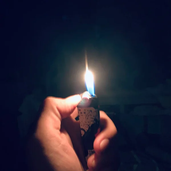 burning candle in the hands of a man