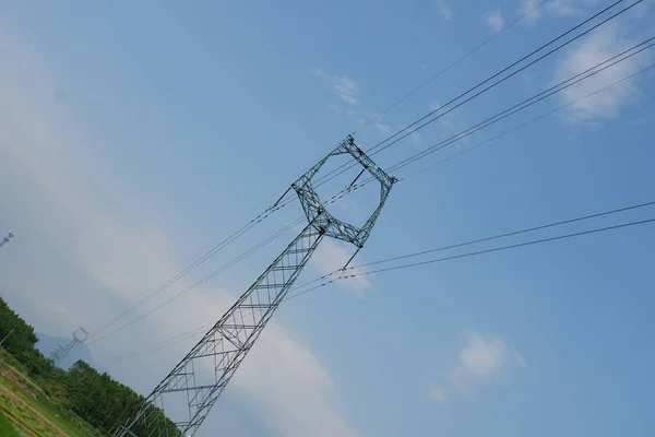 high voltage power line against the blue sky