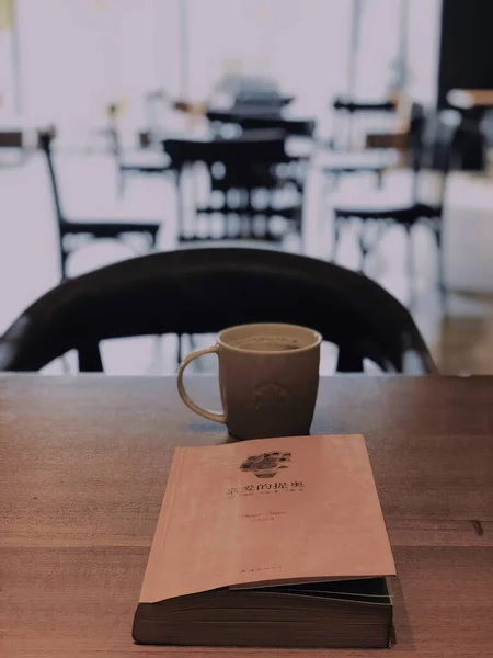 coffee cup and book on table in cafe