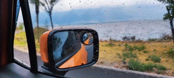 car window with rain drops on the windshield