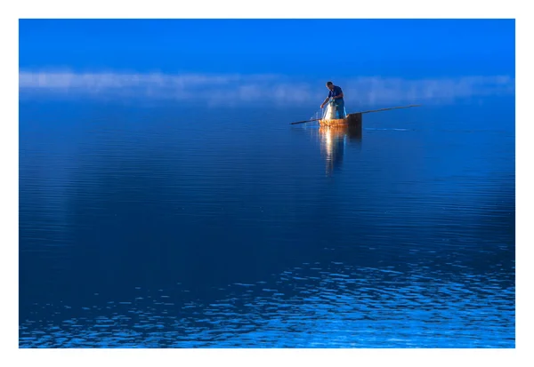 silhouette of a man in a boat on the lake
