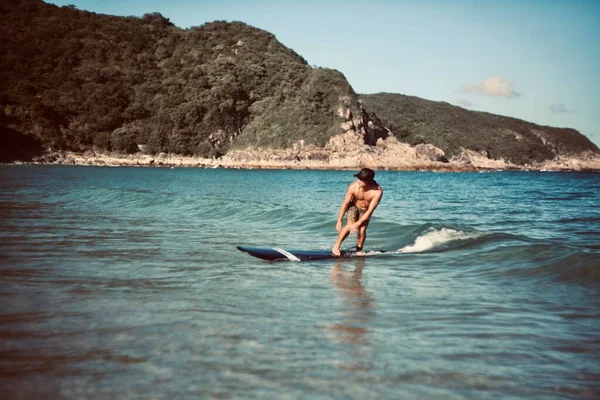 young man in bikini with surfboard on the beach