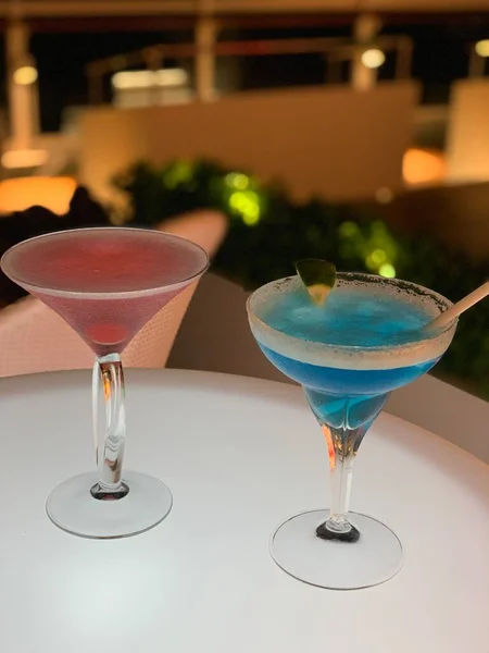 cocktail glass with red and green cocktails on the table