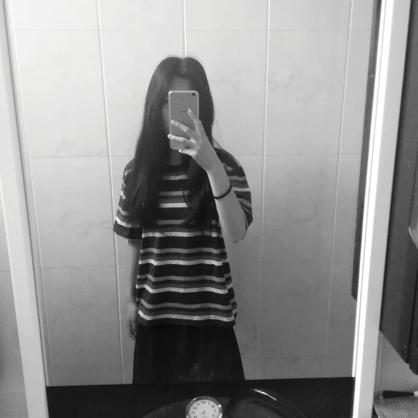 young woman in black clothes and white t-shirt and jeans standing in the bathroom