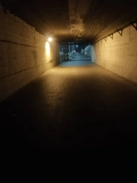 a long shadow of a tunnel with a dark road