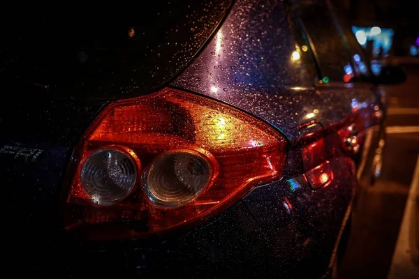 headlights of a red-green sports truck with a black hood