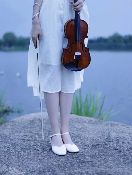 young woman with violin on the beach