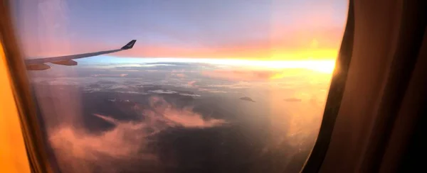 sunset over the window of the plane
