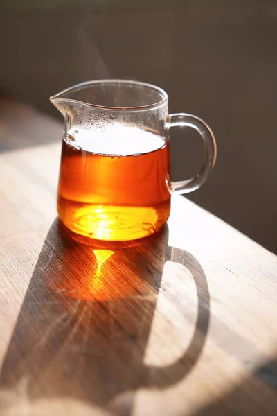 glass of beer and a cup of tea on a wooden table