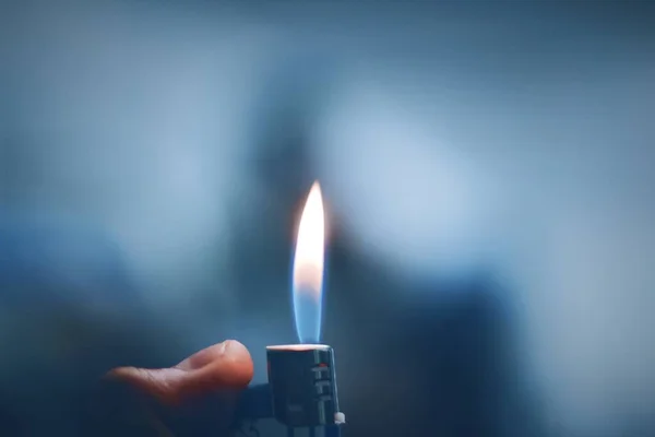 burning candle in the hands of a man