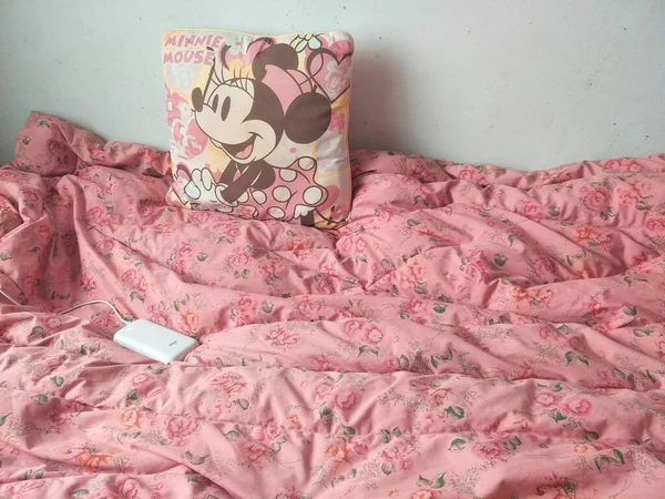 pink pillow and a cup of coffee on the bed