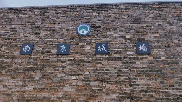 old brick wall with a sign of the house