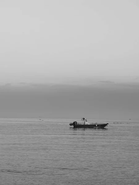 black and white photo of a boat on the sea