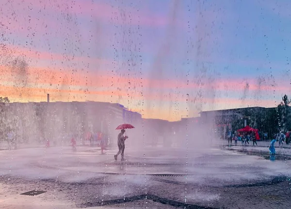 man in a rain puddle on the roof of the building