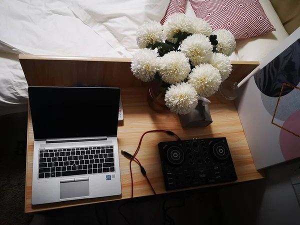 laptop with flowers on bed in bedroom