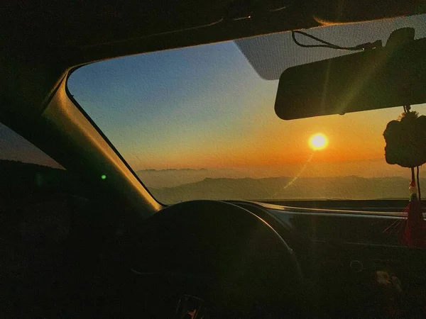 car window with sunset sky