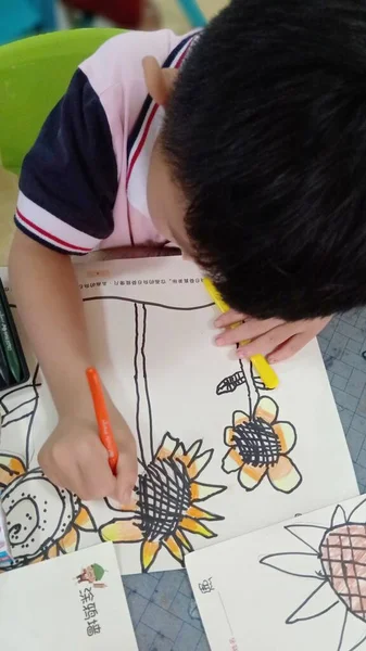 boy draws a pencil on a white sheet
