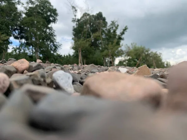 a closeup shot of a pile of stones on a background of a river