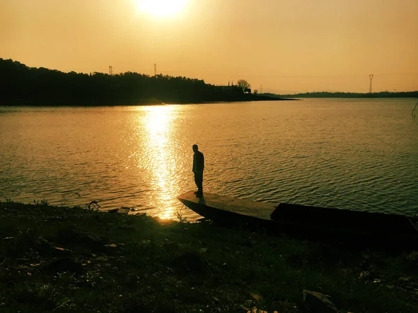 silhouette of a man on the lake