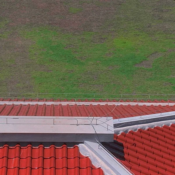 red tiled roof tiles with green grass