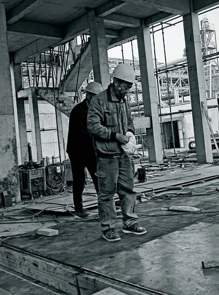 construction worker in a black uniform and a protective mask